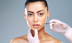 Studio shot of an attractive young woman receiving a botox injection in her face